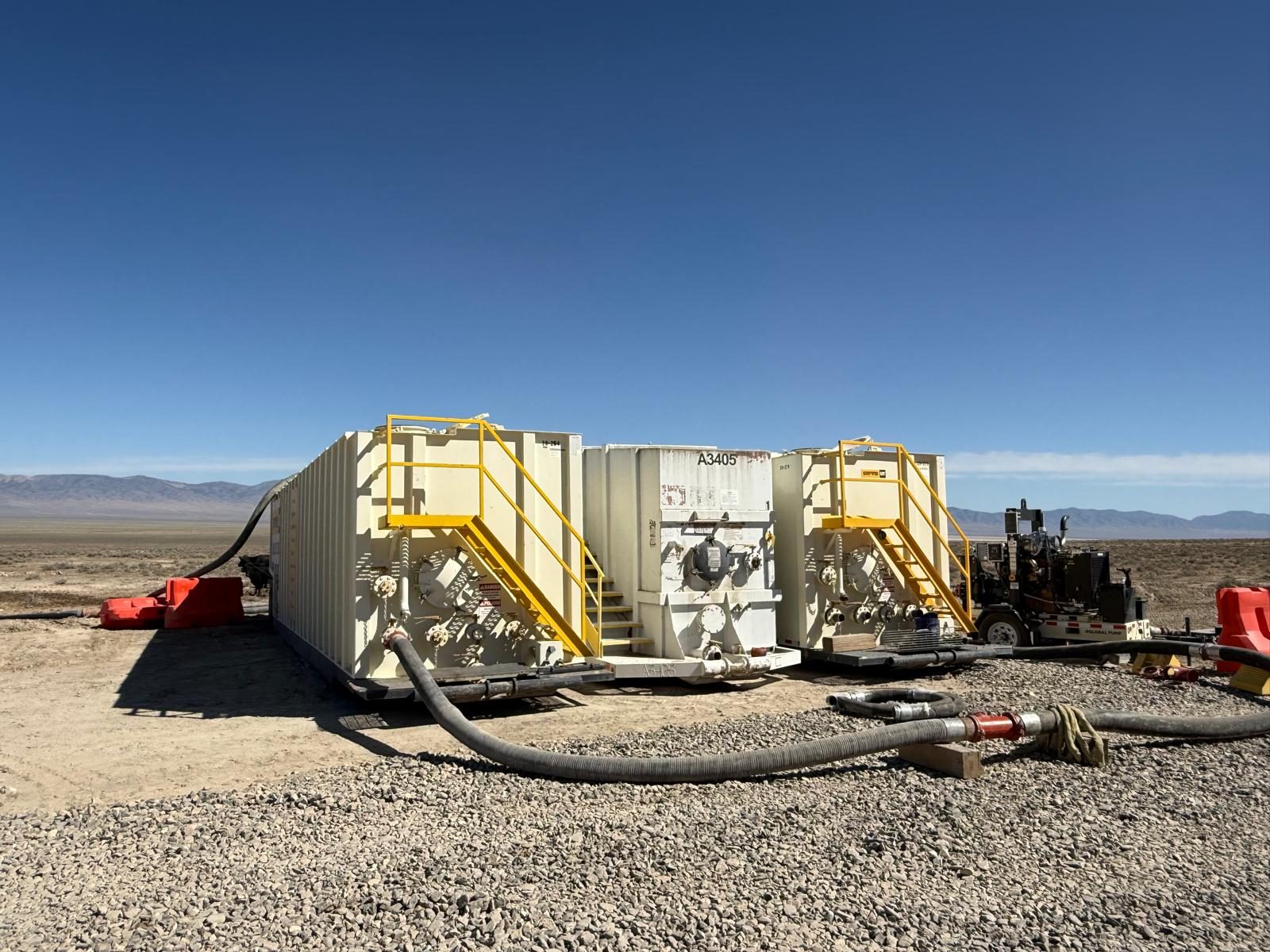 Frac tanks with pump and hoses at a desert mine site